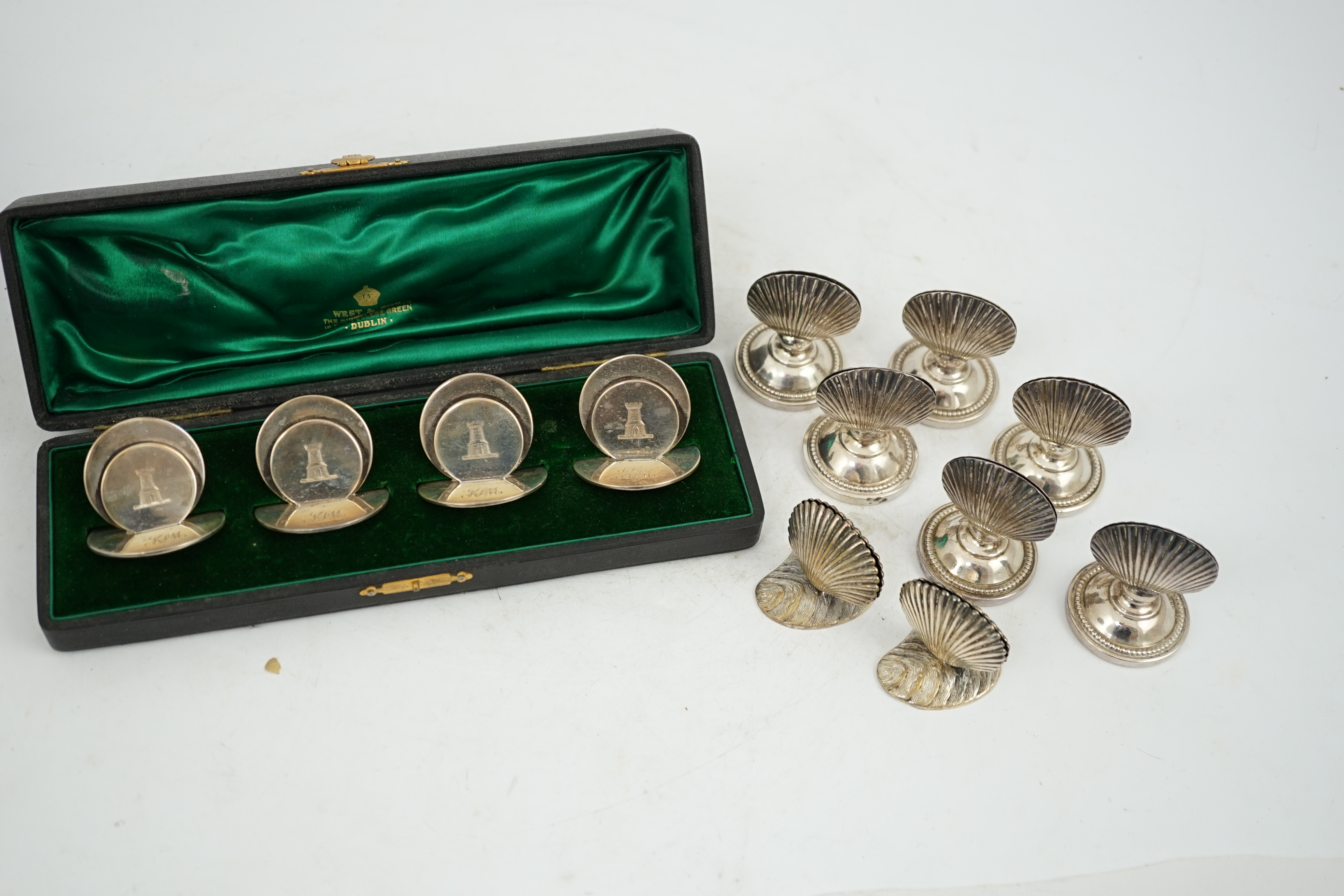 A cased set of four silver menu holders, engraved with castle crest, Sampson Mordan & Co, Chester, 1904, height 37mm, together with eight plated menu holders